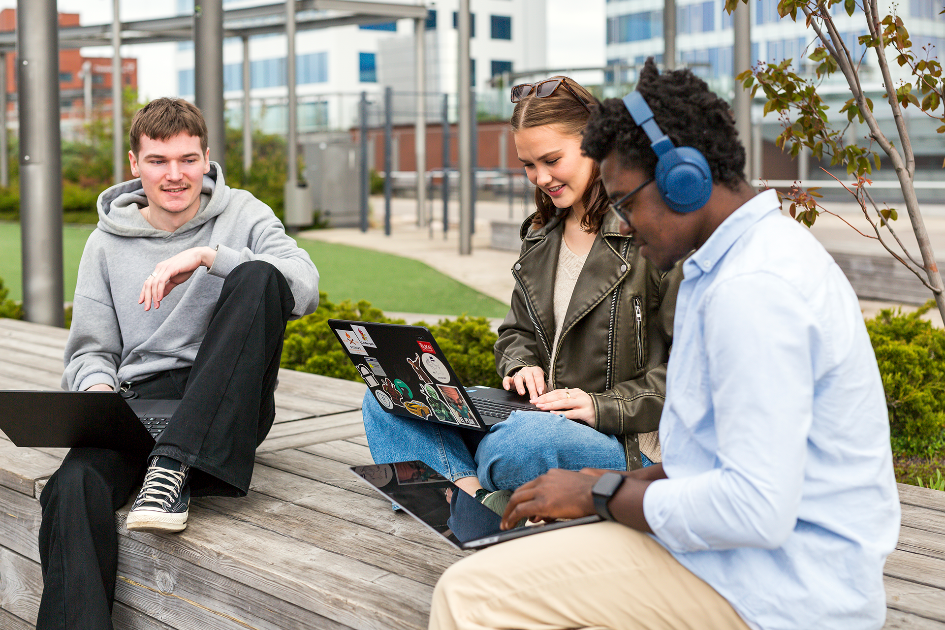 kolme opiskelijaa istuu ulkona